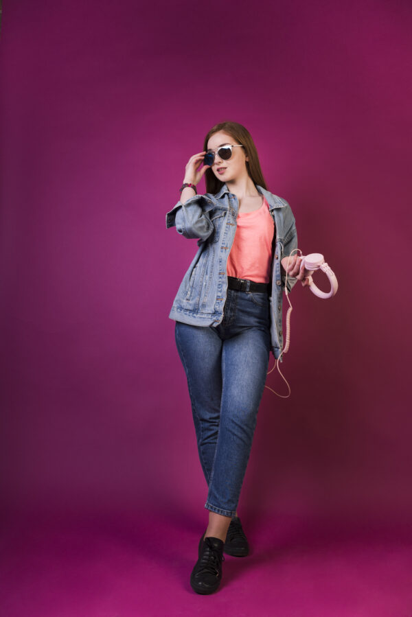 a woman wearing sunglasses and holding headphones
